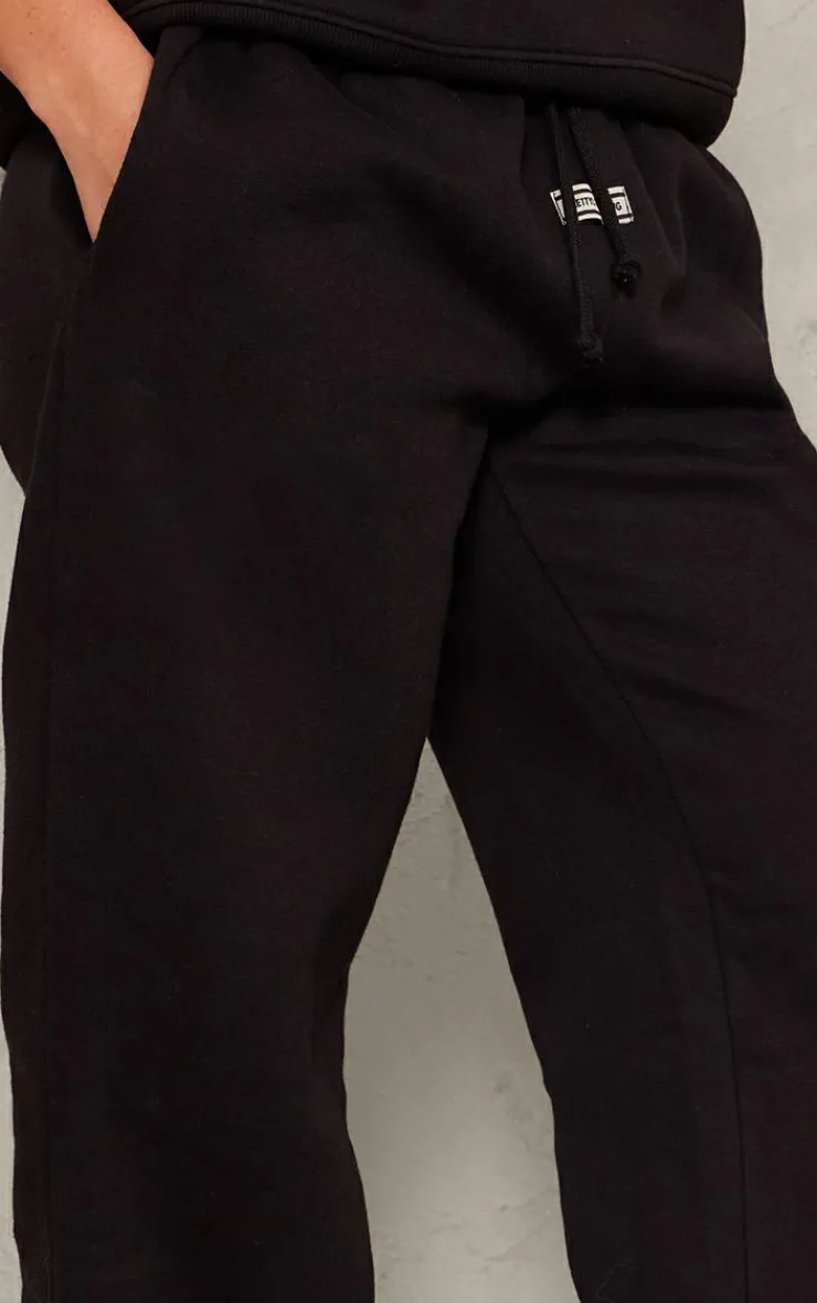 Online PrettyLittleThing Badge Detail Mid Rise Wide Leg Sweatpants Black